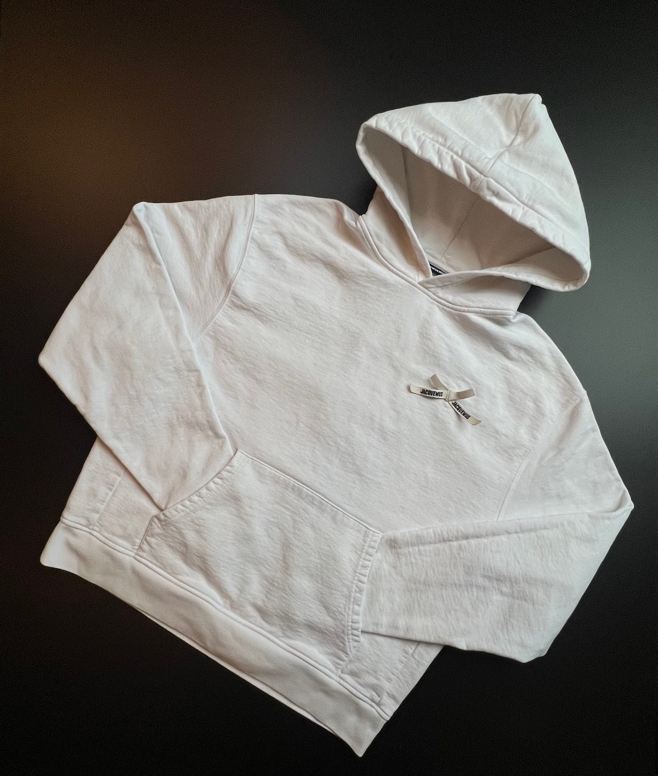 Cream white Jacquemus hoodie in size M, featuring a relaxed fit and minimalist design, displayed against a neutral background.
